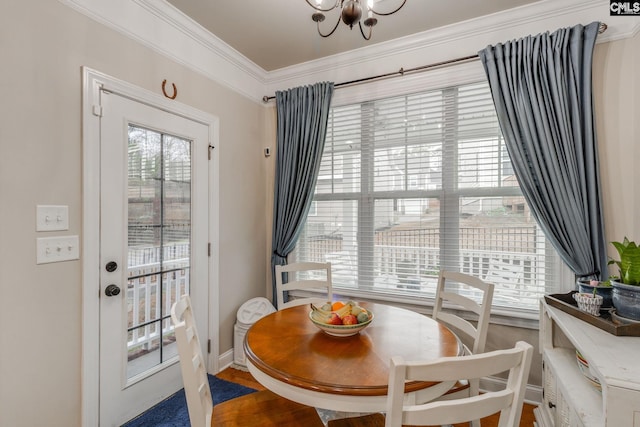 dining area featuring baseboards, ornamental molding, and a notable chandelier