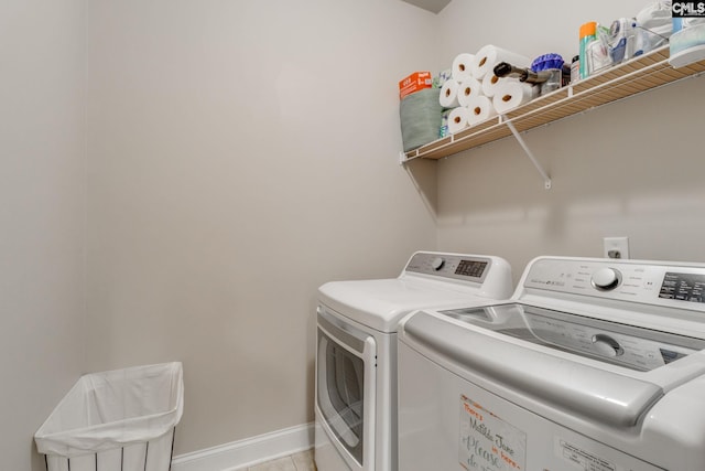 laundry area with laundry area, washing machine and dryer, baseboards, and light tile patterned flooring