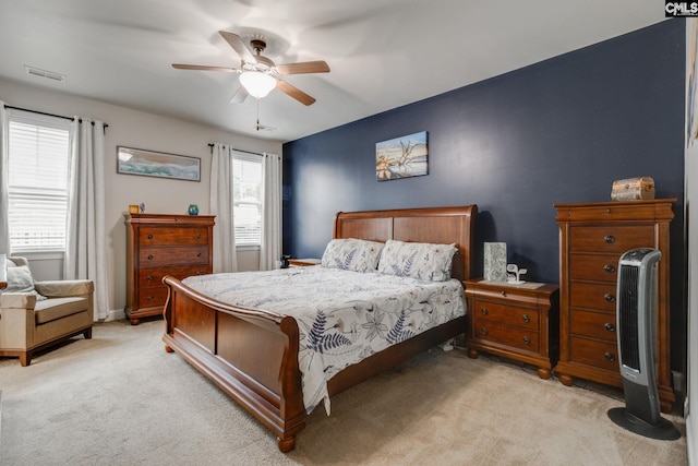 bedroom featuring light carpet, ceiling fan, visible vents, and baseboards