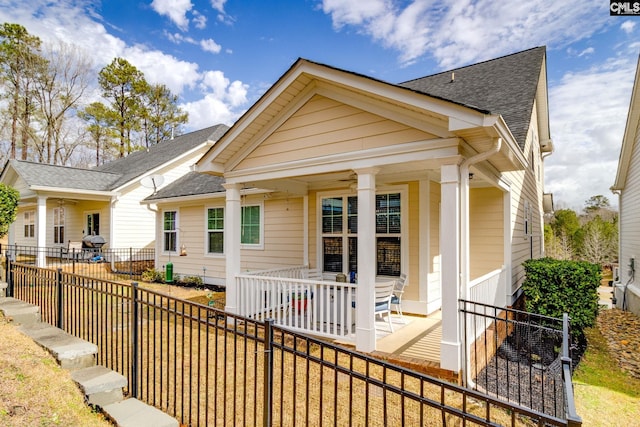 exterior space with roof with shingles and a fenced backyard