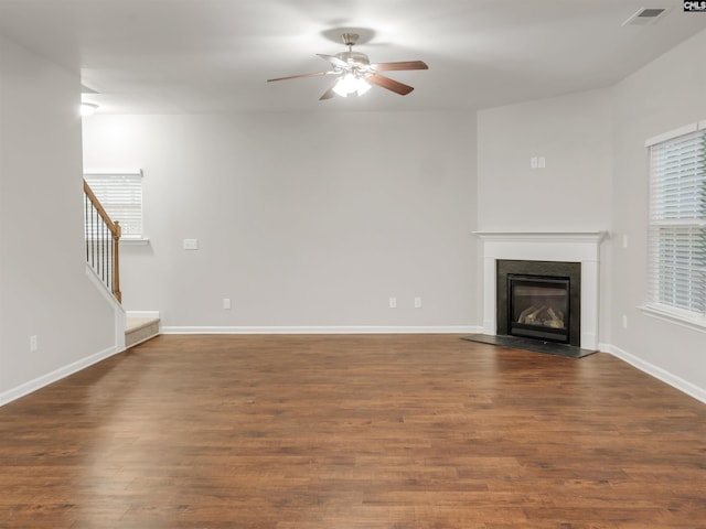1124 Campbell Ridge Dr, Elgin, SC 29045 - unfurnished living room with dark wood-type flooring, visible vents, a ceiling fan, stairway, and a glass covered fireplace
