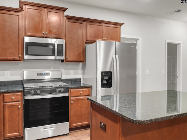 1124 Campbell Ridge Dr, Elgin, SC 29045 - kitchen featuring a center island, light wood finished floors, visible vents, appliances with stainless steel finishes, and dark stone countertops