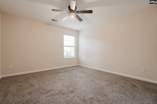 spare room featuring baseboards, carpet, visible vents, and a textured ceiling