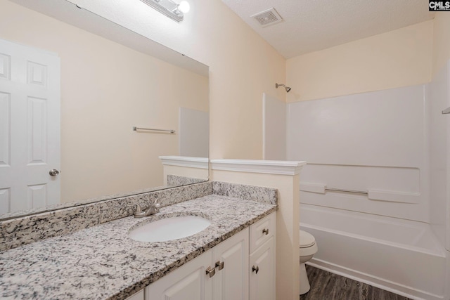 bathroom with shower / bathtub combination, toilet, wood finished floors, vanity, and visible vents