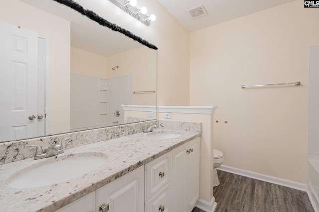 full bath featuring visible vents, a sink, toilet, and double vanity