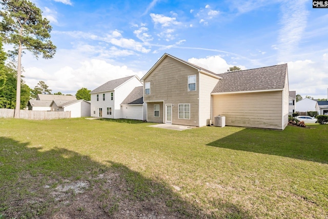 back of property with central AC unit, fence, a yard, roof with shingles, and a patio area