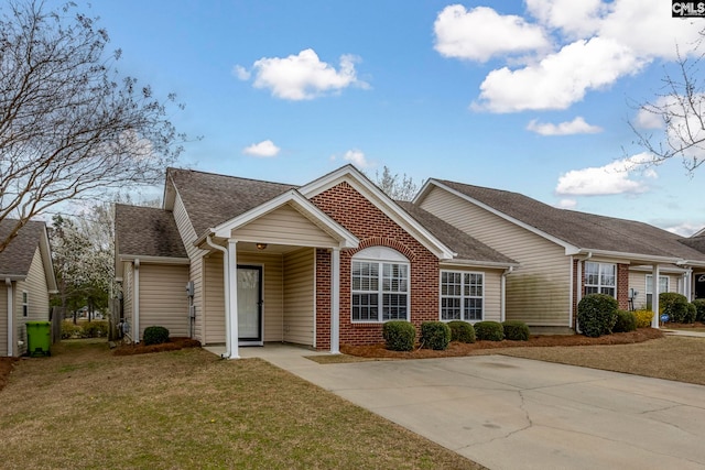 ranch-style home with a front yard, brick siding, and roof with shingles