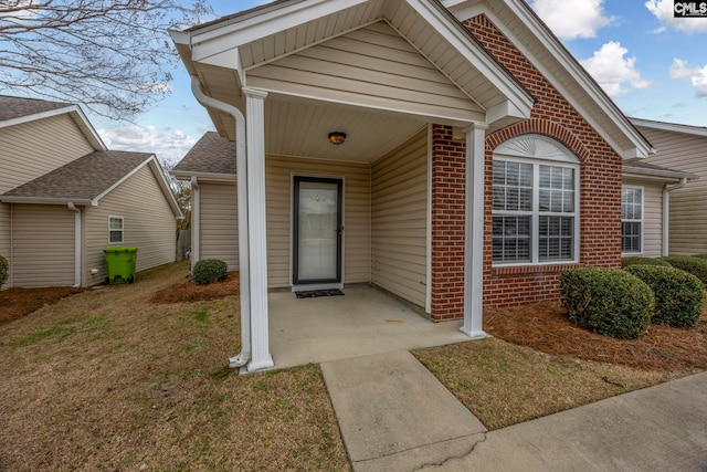 entrance to property featuring brick siding