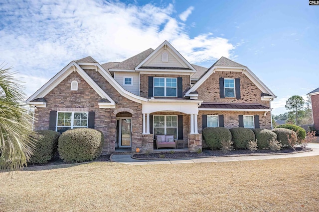 craftsman house with brick siding, roof with shingles, and a front yard