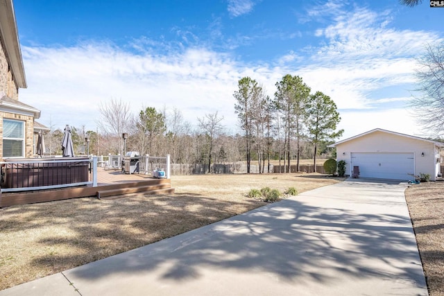 view of yard with a garage, fence, an outdoor structure, and a wooden deck