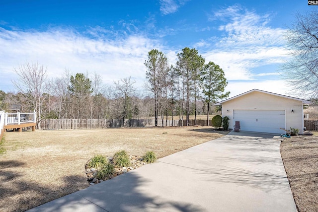 view of yard featuring a garage, driveway, and fence