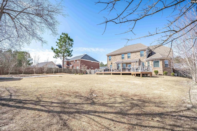 back of property featuring a deck and fence