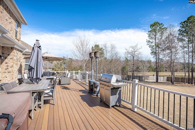 wooden terrace featuring a grill and fence