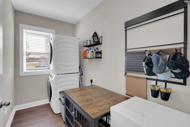 washroom with baseboards, laundry area, wood finished floors, and stacked washer / drying machine