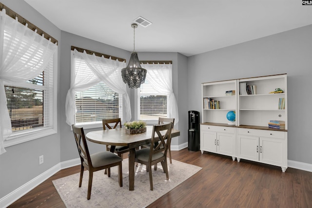 dining space with dark wood-style floors, visible vents, baseboards, and a chandelier