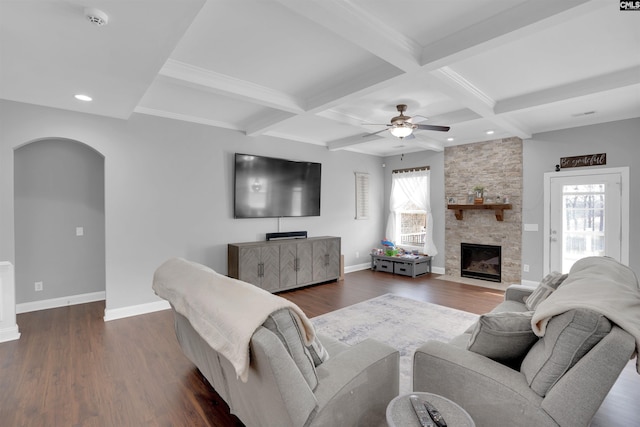 living room with arched walkways, dark wood-style flooring, a fireplace, and baseboards