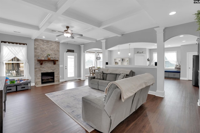 living room featuring dark wood-style flooring, a healthy amount of sunlight, and ornate columns