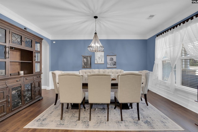 dining space featuring visible vents, ornamental molding, dark wood-style flooring, and a notable chandelier