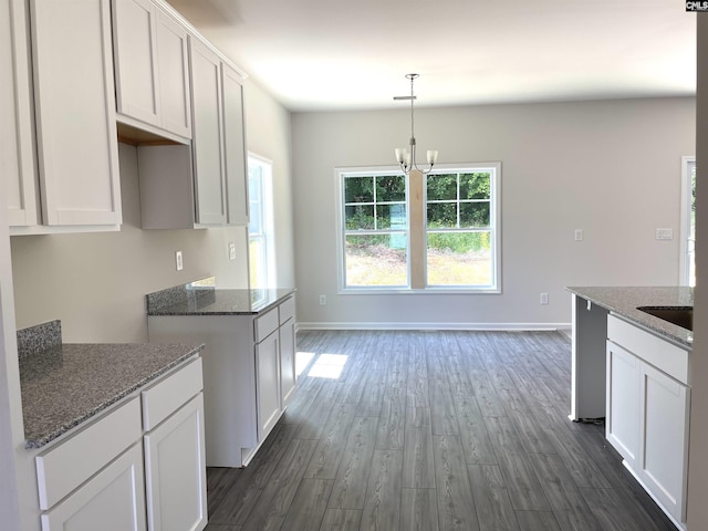 kitchen featuring dark wood-style floors, stone countertops, and white cabinetry
