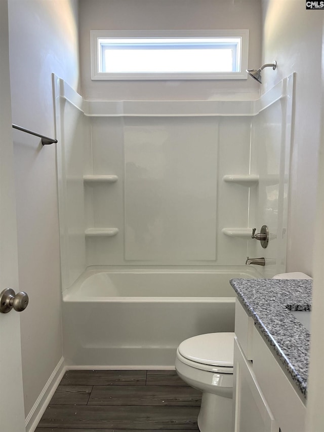 bathroom featuring shower / bath combination, toilet, vanity, wood finished floors, and baseboards