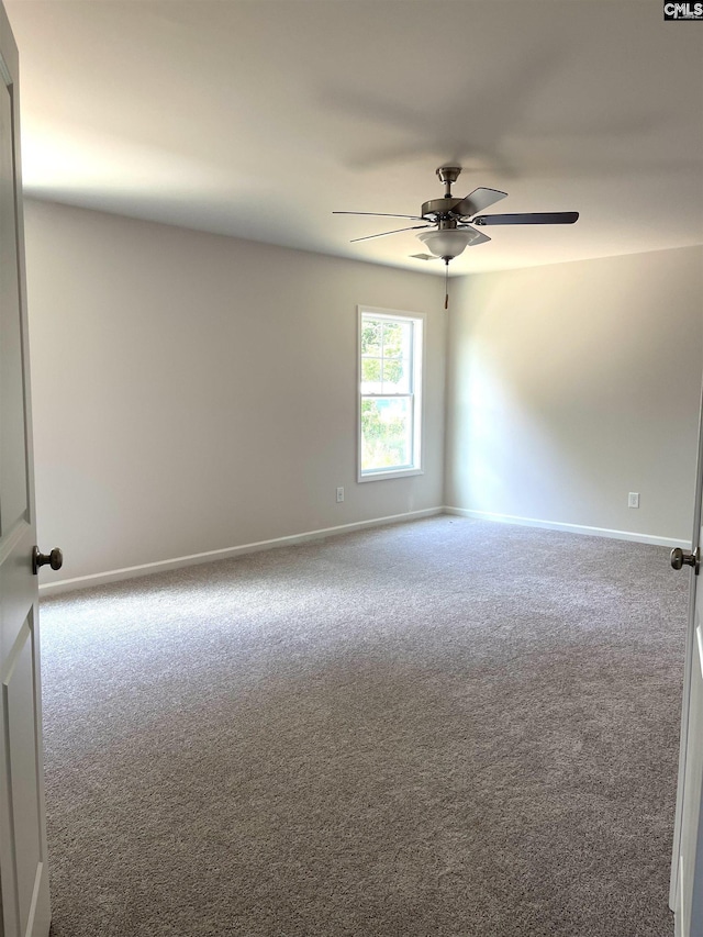 spare room featuring ceiling fan, carpet floors, and baseboards