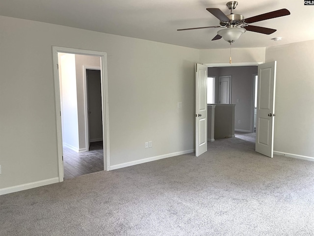 unfurnished bedroom with carpet, a ceiling fan, and baseboards