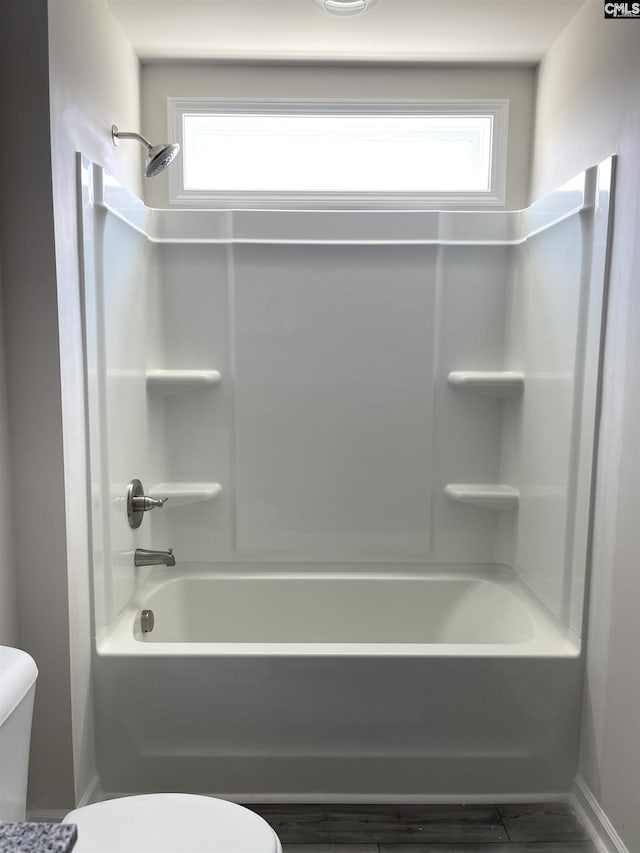 bathroom with toilet, plenty of natural light, and shower / bathtub combination