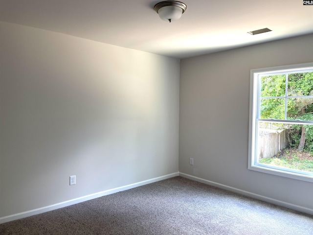 unfurnished room featuring carpet and baseboards