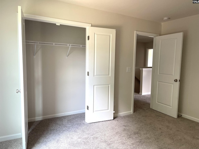 unfurnished bedroom featuring a closet, carpet flooring, and baseboards