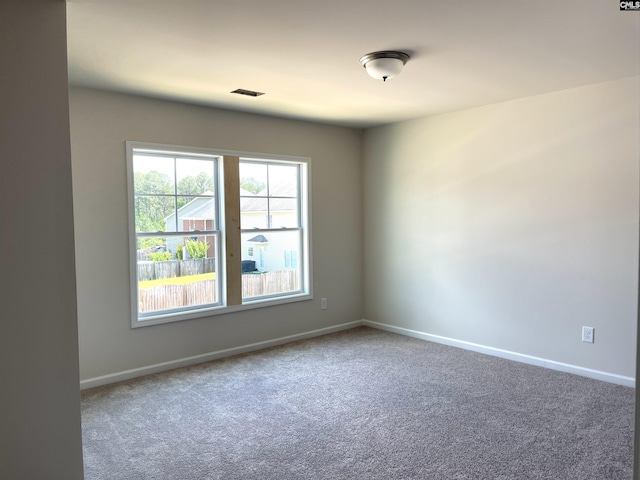 empty room featuring baseboards, visible vents, and carpet flooring