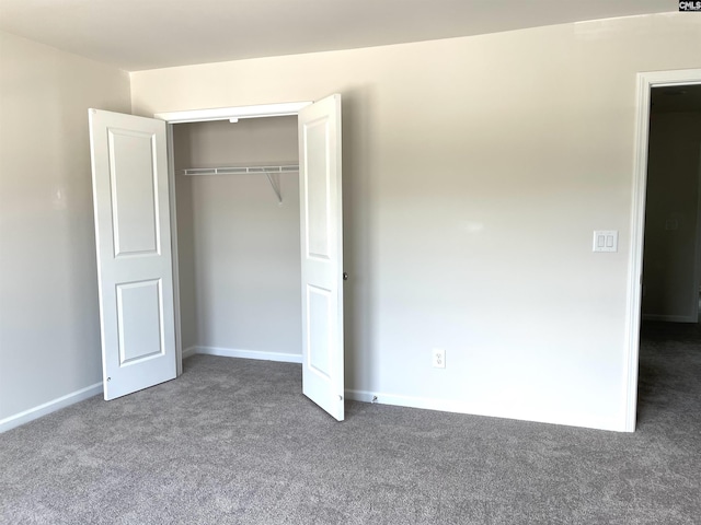 unfurnished bedroom with a closet, baseboards, and carpet flooring