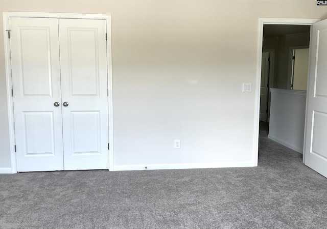unfurnished bedroom with a closet, carpet flooring, and baseboards
