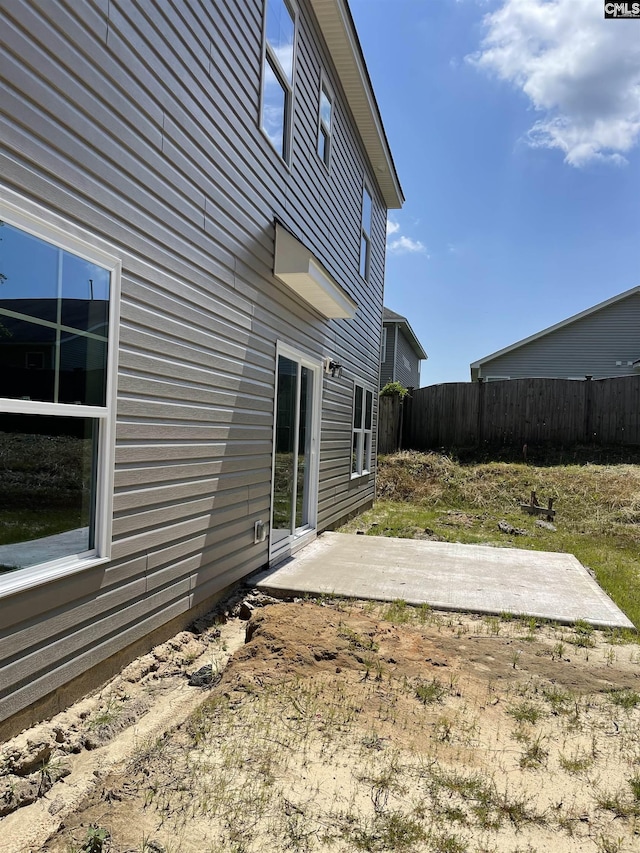 rear view of house with a patio and fence