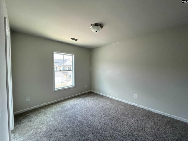 spare room featuring carpet floors and baseboards