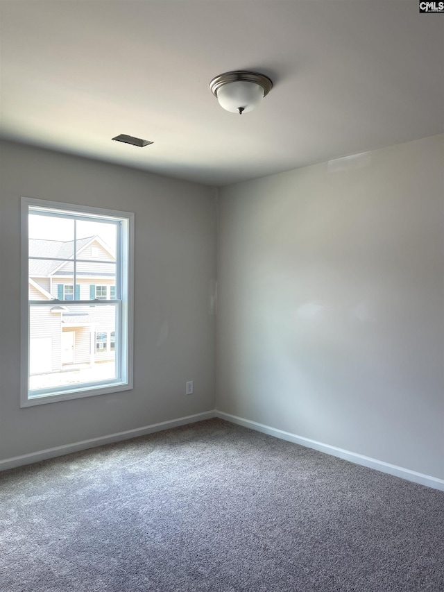 empty room featuring carpet and baseboards