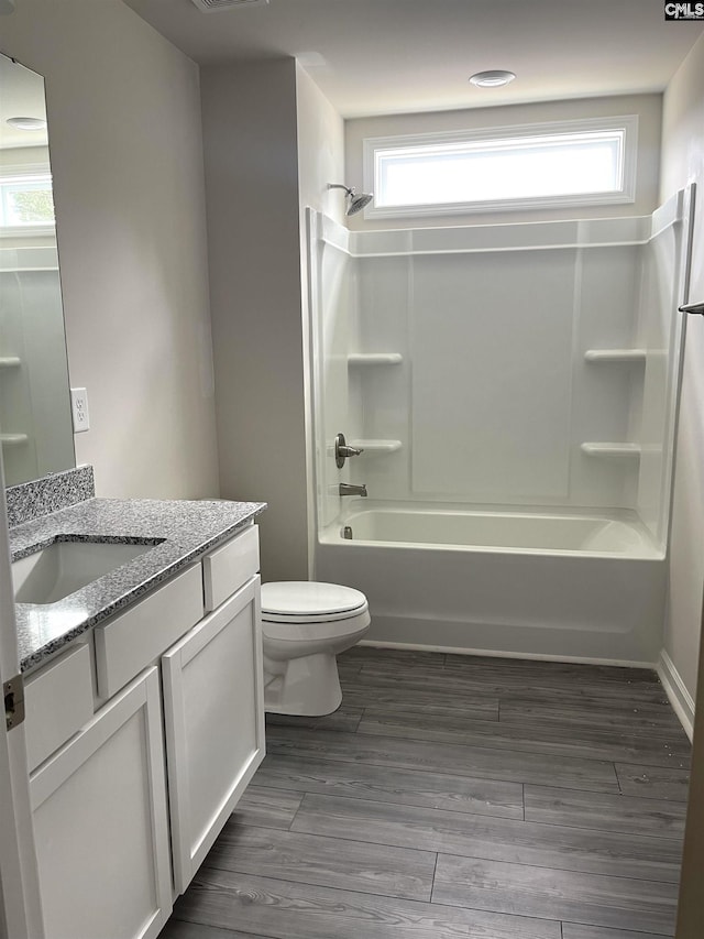 full bathroom with vanity, wood finished floors, bathtub / shower combination, and toilet