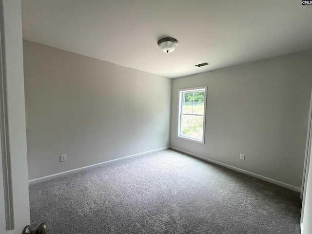 carpeted spare room with visible vents and baseboards