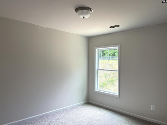 carpeted empty room featuring baseboards