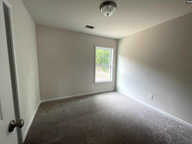 unfurnished room with carpet flooring and baseboards