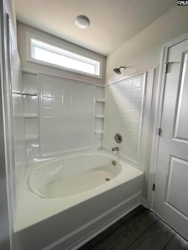 bathroom with bathtub / shower combination, a wealth of natural light, and wood finished floors