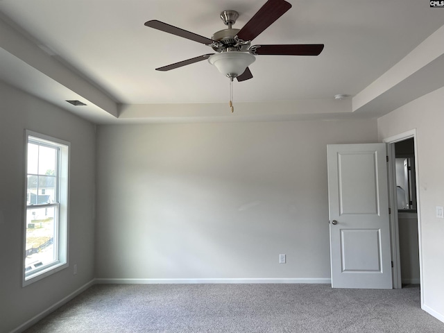 carpeted empty room featuring ceiling fan, visible vents, and baseboards