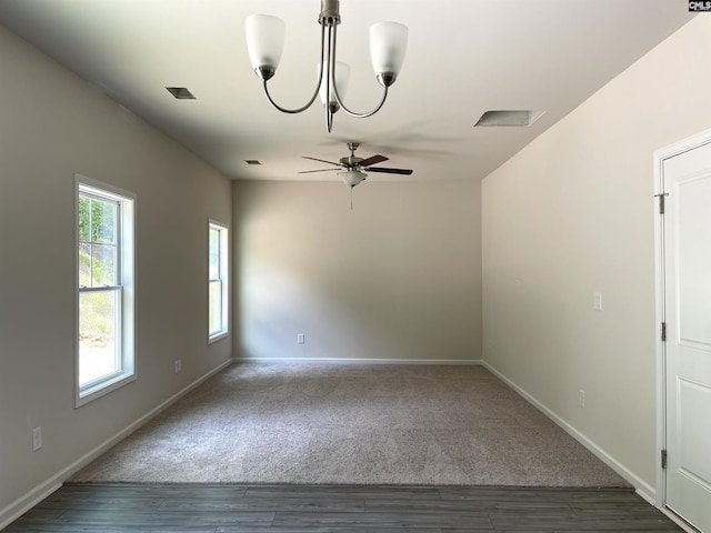 spare room with wood finished floors, visible vents, baseboards, and ceiling fan with notable chandelier