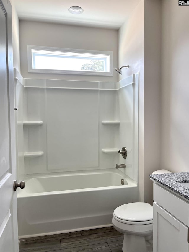 full bathroom with toilet, wood finished floors, vanity, and a healthy amount of sunlight