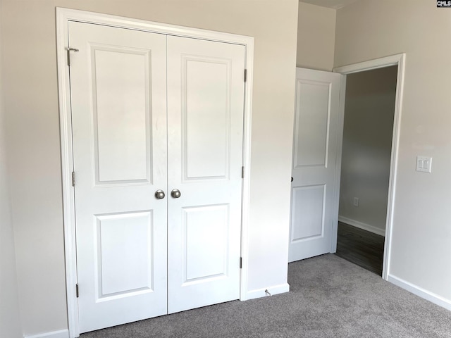 unfurnished bedroom featuring a closet, carpet flooring, and baseboards