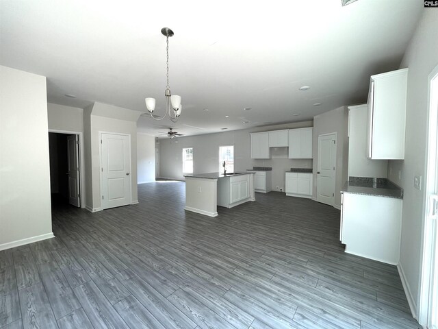 kitchen featuring dark wood-type flooring, open floor plan, white cabinets, and baseboards