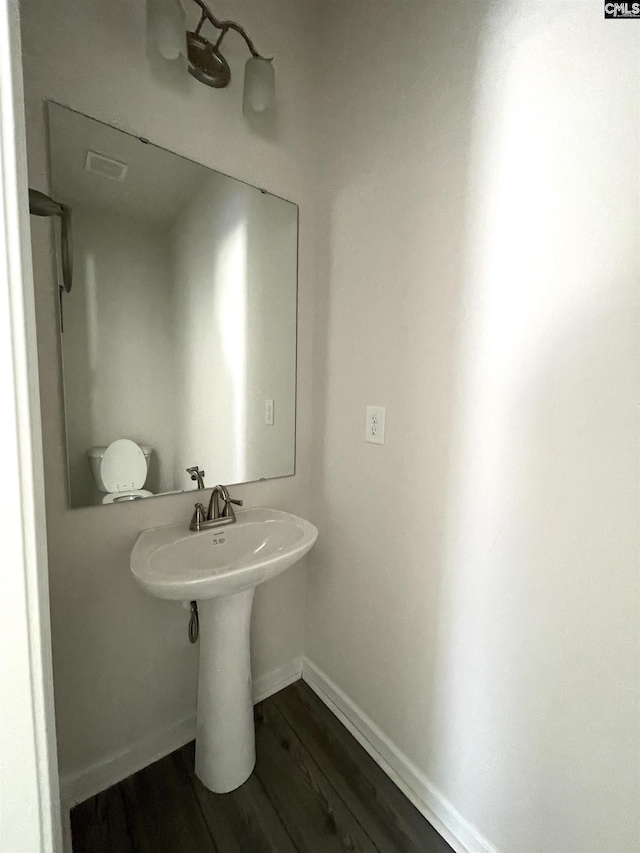 bathroom featuring wood finished floors, visible vents, and baseboards