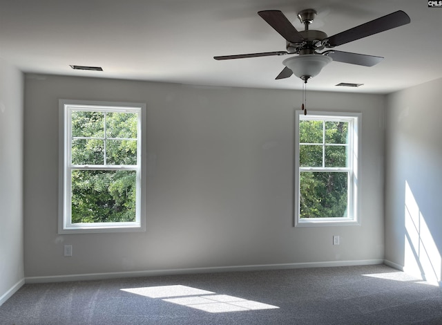 unfurnished room featuring carpet, visible vents, and baseboards