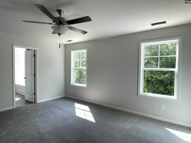 carpeted spare room with baseboards, visible vents, and a ceiling fan