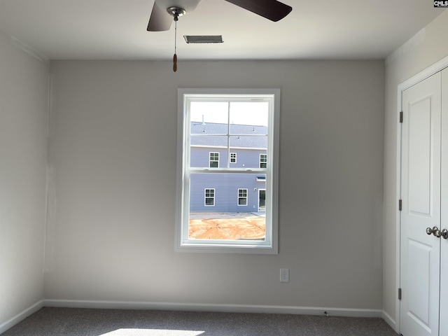 unfurnished room featuring a ceiling fan, visible vents, baseboards, and carpet flooring