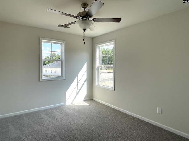 carpeted empty room with ceiling fan and baseboards